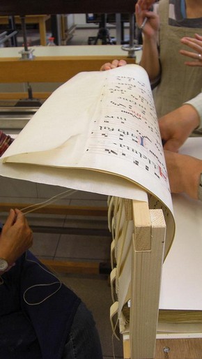 Figure 4. The book conservator and Chris Clarkson sewing the manuscript (Photography by Anne Bancroft)