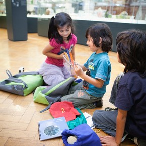 Family working with the V&A activity backpack in the glass gallery.