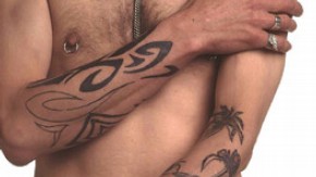 Man with piercing and tattooed forearms