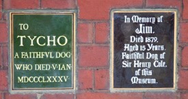 Two plaques located on a wall in the garden commemorating Henry Cole's dog Jim and another 'faithful dog' Tycho.
