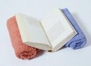Supporting a book using clean rolled towels.