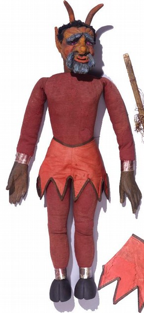A 19th century marionette of the devil, Theatre Museum. The skirt is a satin weave cotton, which has been repaired using a neutral coloured fabric and couch stitching. Museum no. S.305-1999