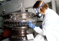 Conservator at work on a silver bowl